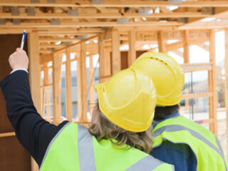 house frame work being inspected by construction workers