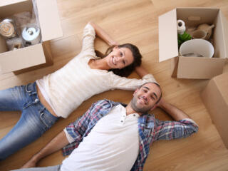 a couple lying in their living room packing for a move