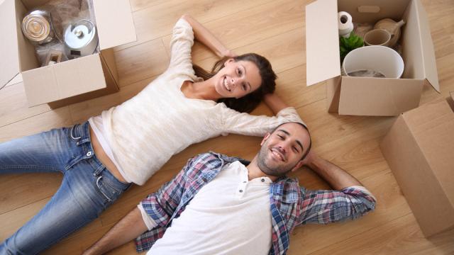 a couple lying in their living room packing for a move