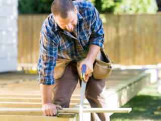 man cutting treated lumber for a deck