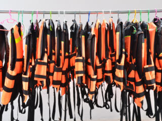 life jackets hanging from a metal rod