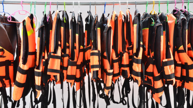 life jackets hanging from a metal rod