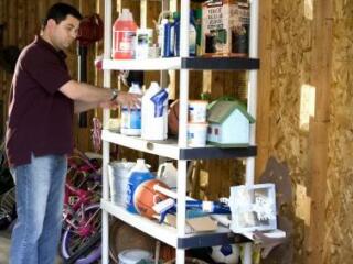 man standing in garage in front of overloaded storage rack