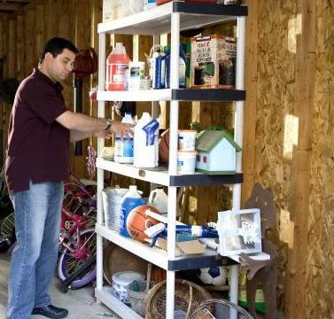 man standing in garage in front of overloaded storage rack