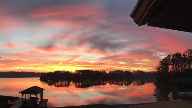 yellow, pink and grey sunset over lake from porch