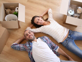 couple lying on the floor with boxes around them
