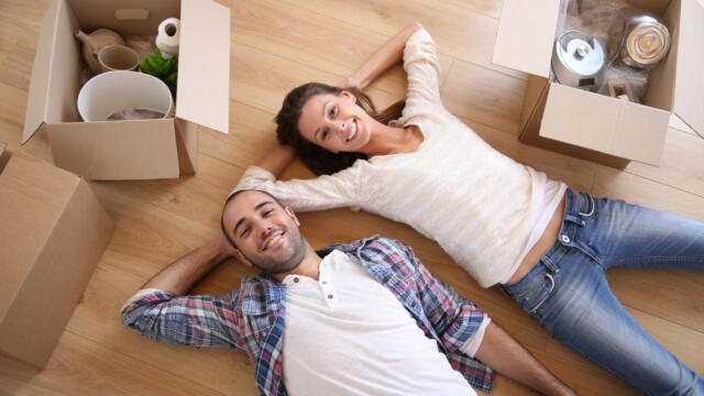 couple lying on the floor with boxes around them
