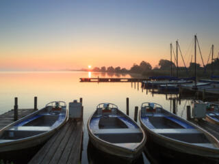 three boats docked at sunset