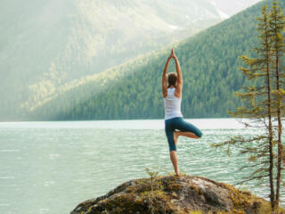 Lady doing yoga at a clean lake
