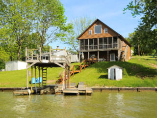 wood plank multi tier home with boat dock on water