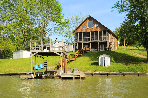 wood plank multi tier home with boat dock on water