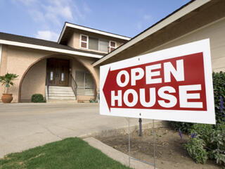 home with open house sign in front of it