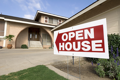 home with open house sign in front of it