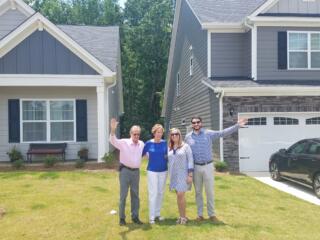 Lake Homes Realty clients, The Morrisons with daughter and son-in-law, in front of new homes.