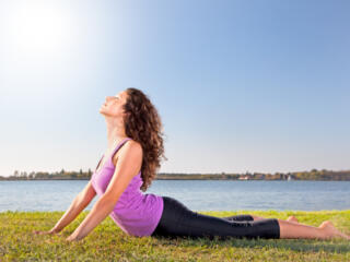 Woman in cobra yoga pose, healthy living at the lake