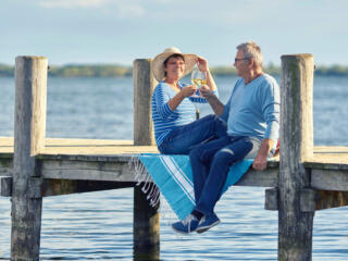 retired couple toasting on the dock on one of America's best retirement lakes