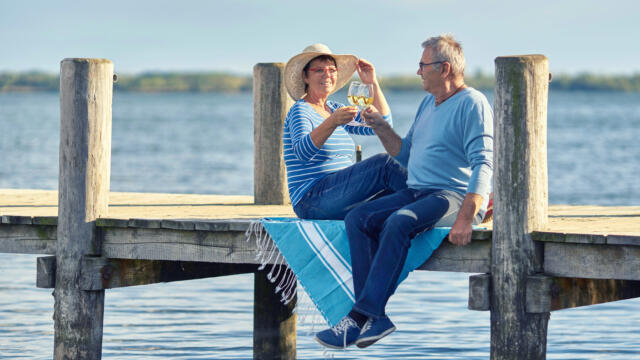 retired couple toasting on the dock on one of America's best retirement lakes