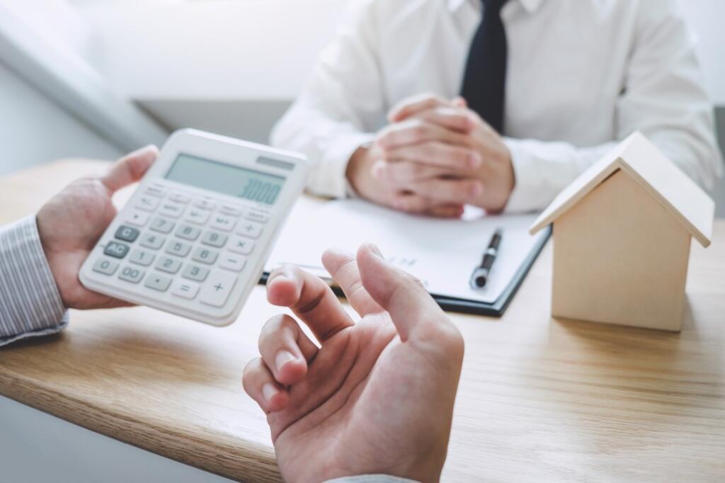 man holding calculator explaining the top 10 tips on waterfront property buying