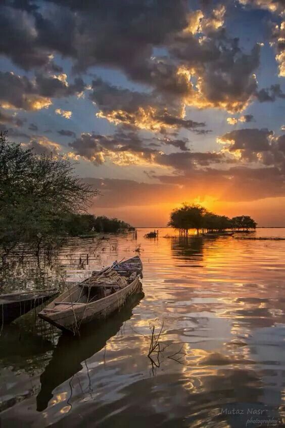 canoe on lake during sunset with clouds