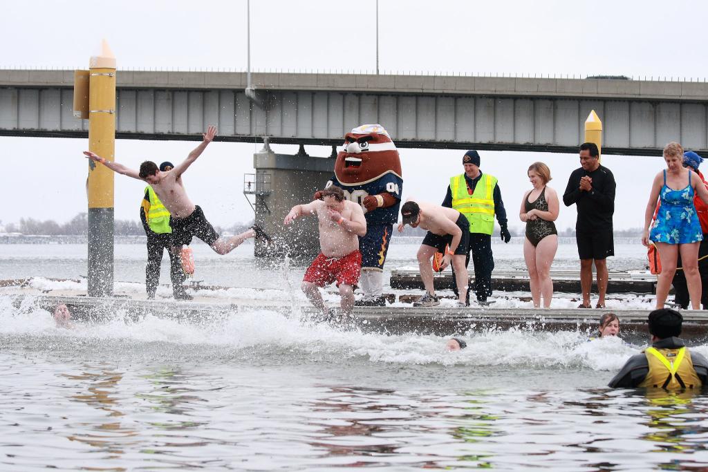people jumping into cold water for a polar plunge