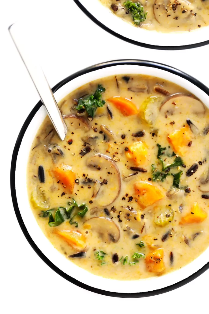 Autumn Wild Rice Soup, containing mushrooms, carrots, kale, and Old Bay seasoning. 