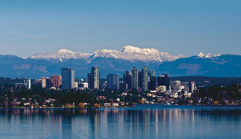 A view of Seattle Washington with mountains in the background taken from Lake Washington.
