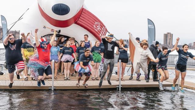 People dressed in costumes jumping into Lake Nokomis for a polar plunge