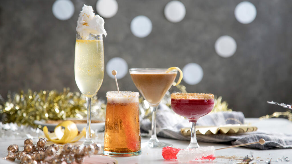 Four cocktails of different sizes in front of festive decorations. 