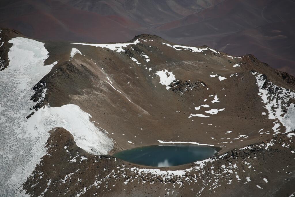 Tall mountain with small body of water nestled in it. 