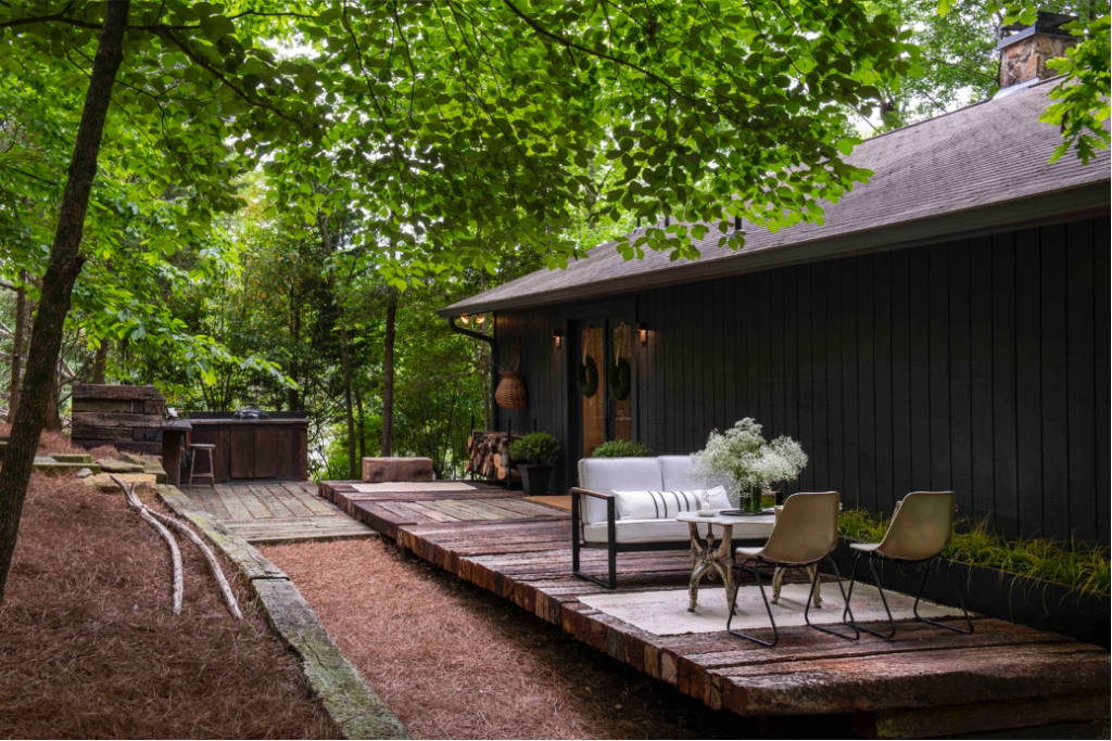 Front porch of reclaimed family cabin with grilling station and intimate seating area