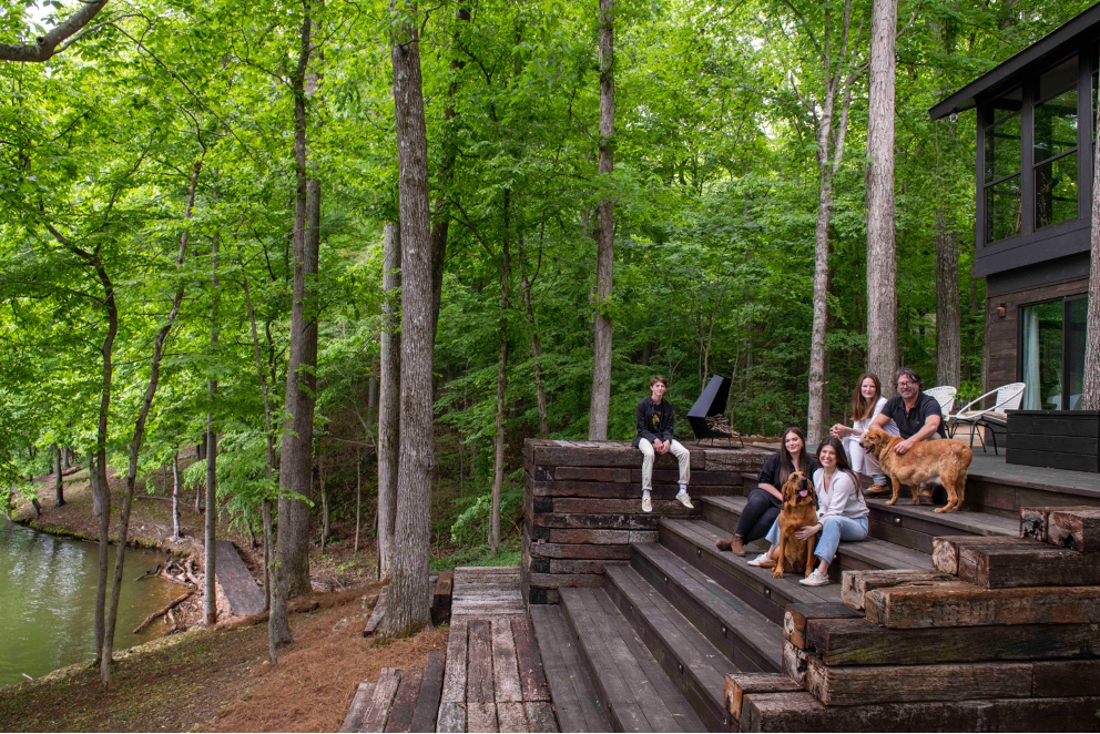 Billy Reid and family with dog on steps in front of Wilson Lake, Alabama