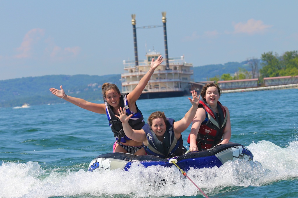 three young women on a tube in a lake 