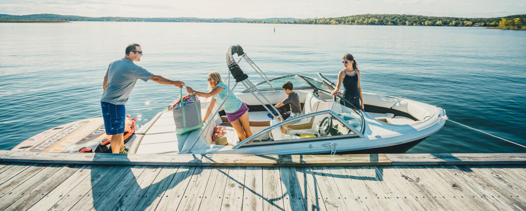 family getting in boat on lake 