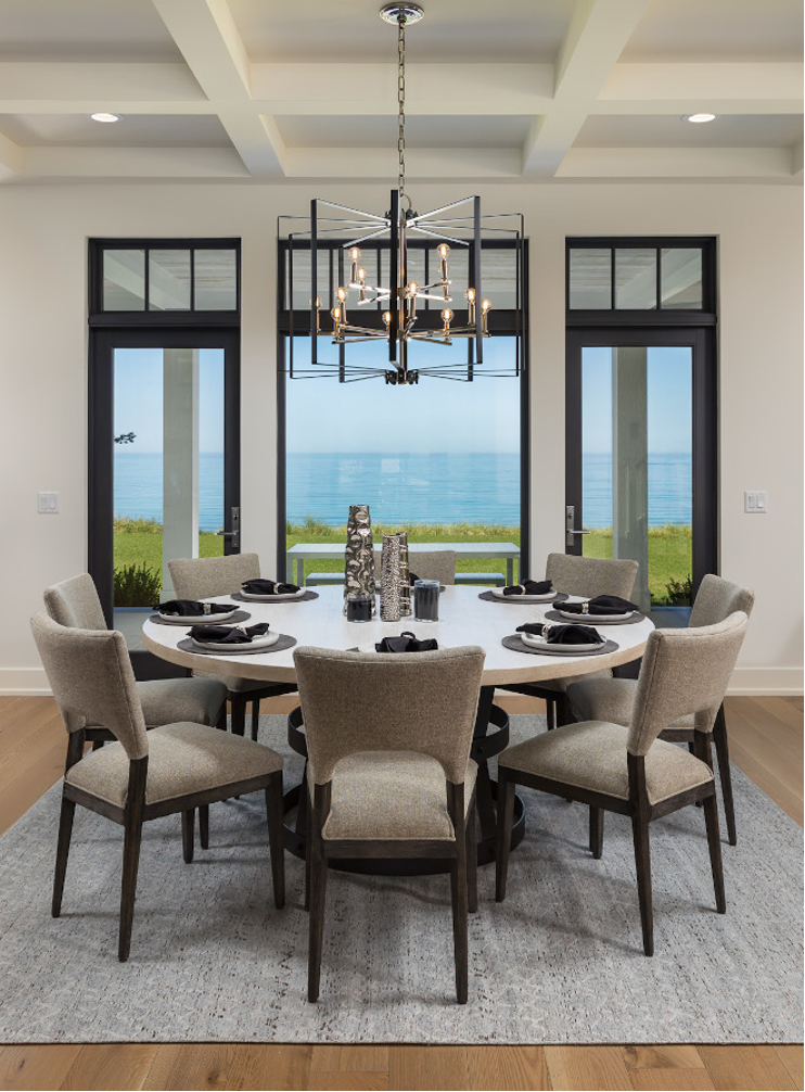Dining space with oversize pendant light, waterfront lake view, round dining table, cozy dining space, 8 chairs, area rug