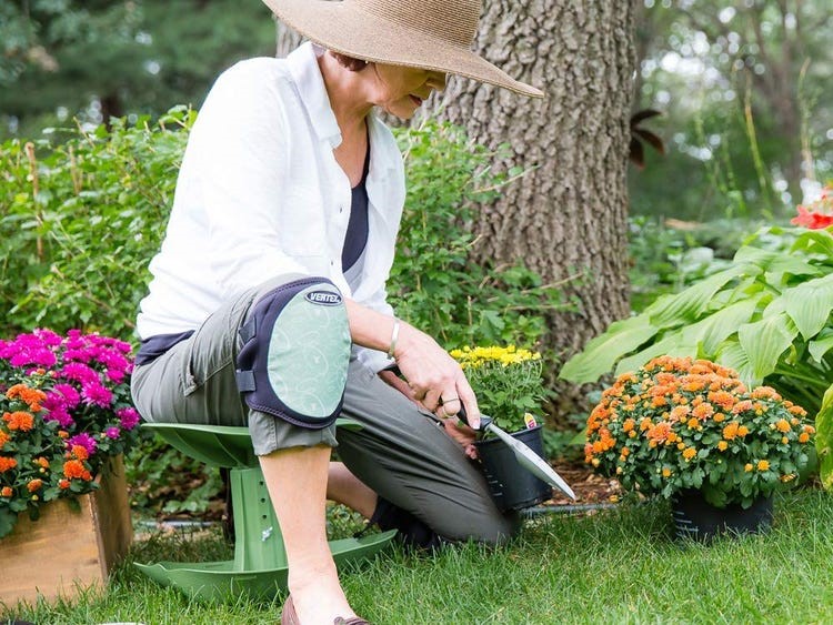 older woman in a garden with flowers