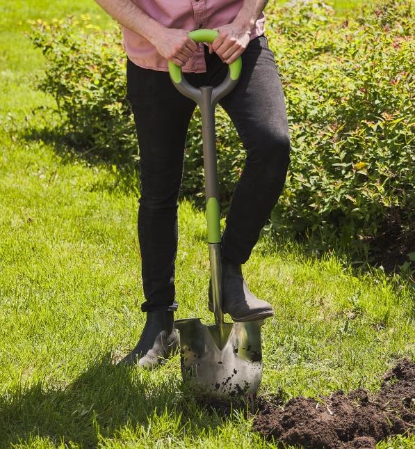 person with their foot on a garden shovel