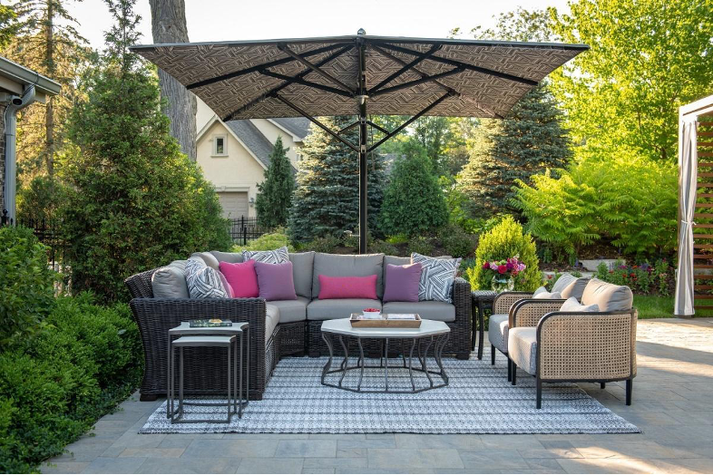 Outdoor seating on patio with bright pillows and an umbrella 