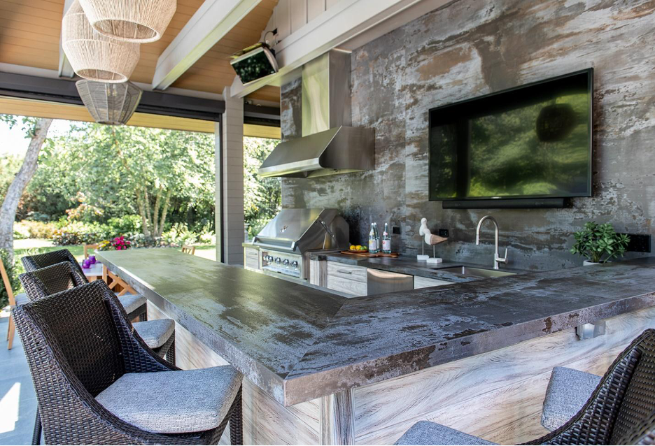 Dekton feature wall and outdoor kitchen countertops with barstools