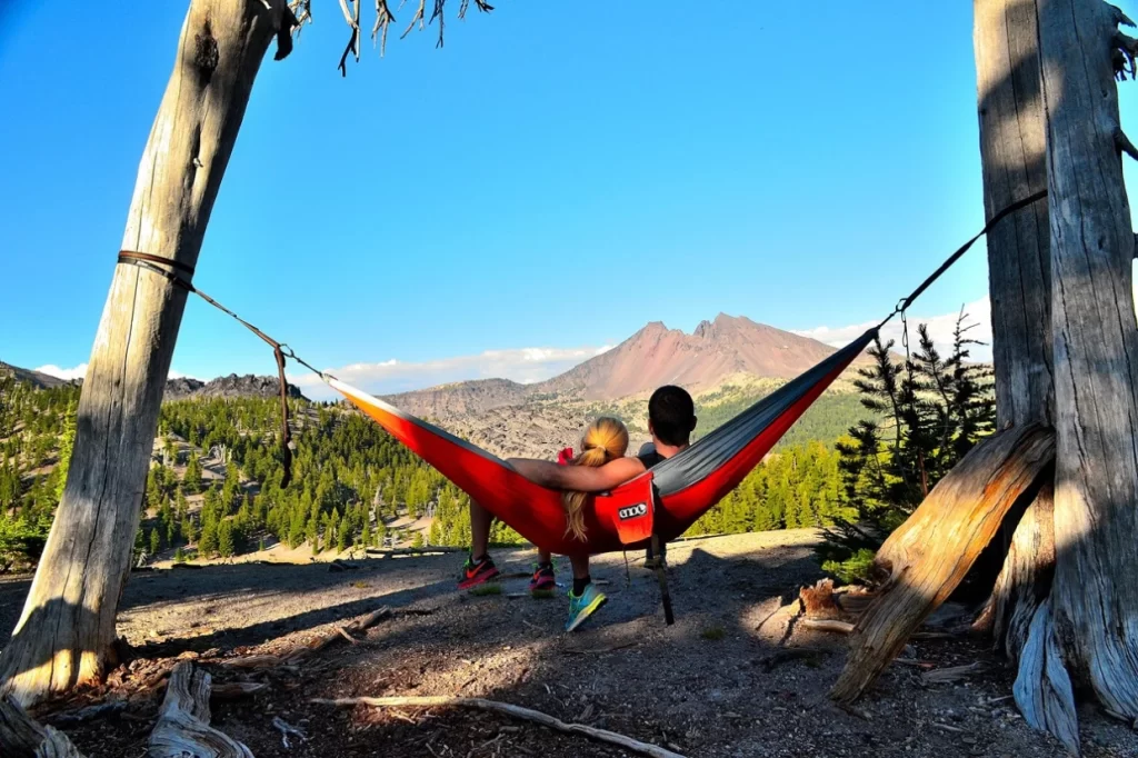 Two people in an ENO hammock looking off to the mountainside