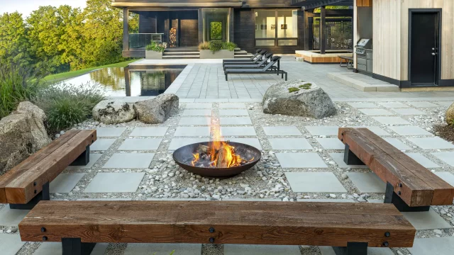 patio with stone pavers, rocks, gravel, fire pit, and pool