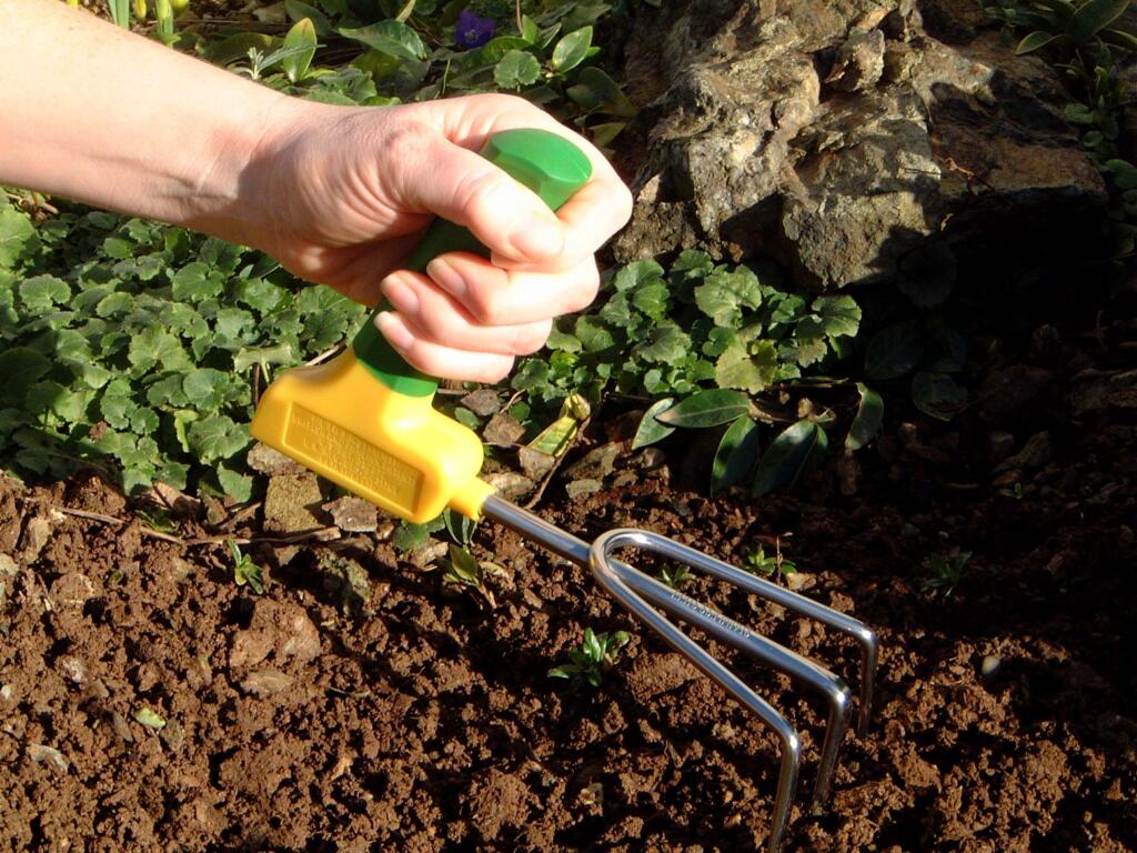 a hand using the Peta Easi-Grip Garden Tools Set in the dirt