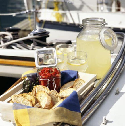 lemonade in mason jar and tray of break and fruits on a boat