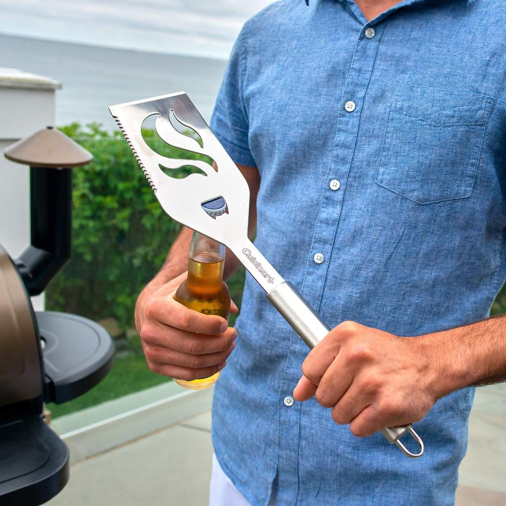 Guy using spatula bottle opener from the Cuisinart® 20-Piece Grill Set from Crate and Barrel