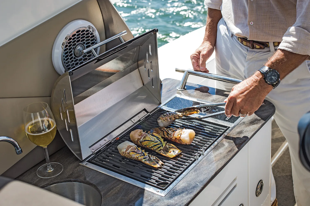 Kenyon built-in electric grill on a boat with guy grilling seafood
