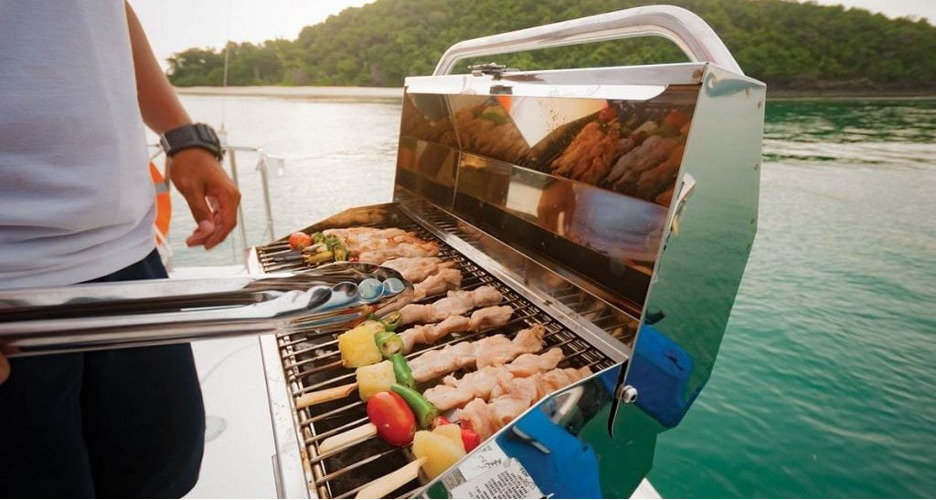 Guy cooking food on mounted boat grill from Citimarine Store