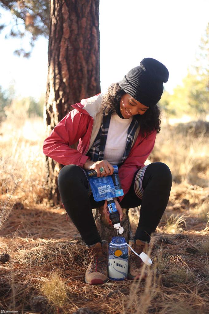 woman pouring purified water into water bottle