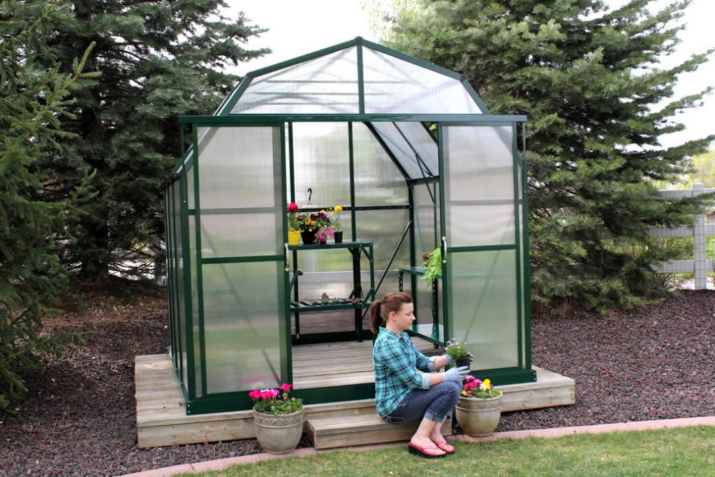 Grandio Greenhouse with woman sitting in front