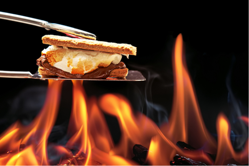 S'more on spatula tongs over open flames