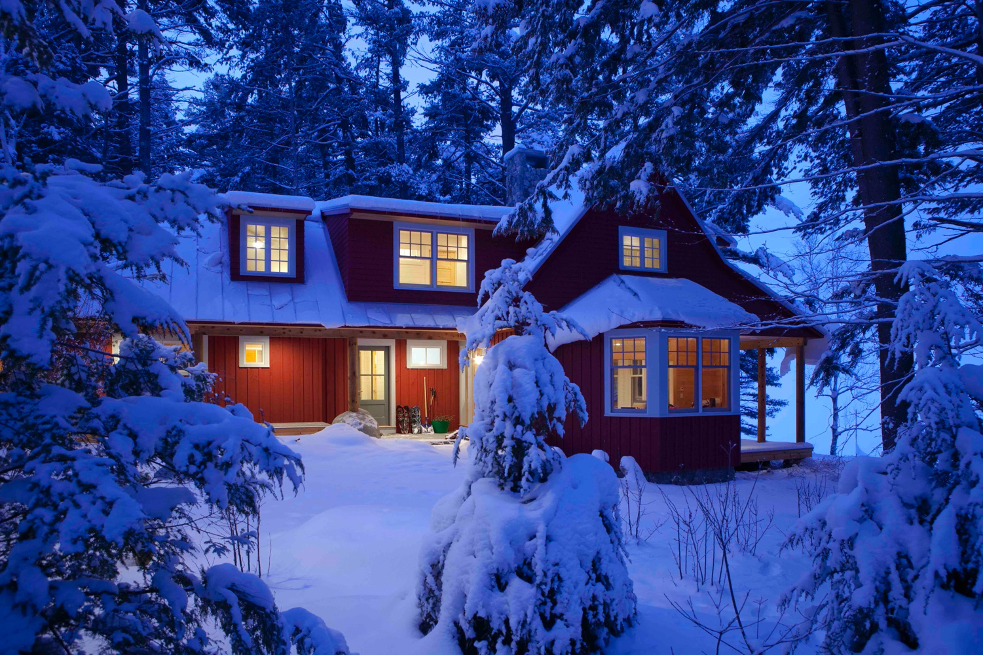 Side view of lake home with trees covered in snow