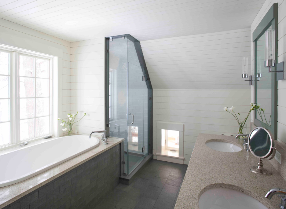 master bath with long tub, shower, and tiny window at the floor